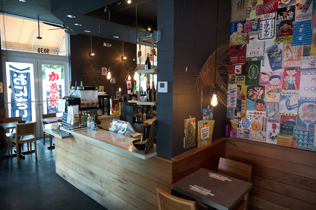 Umaimon restaurant interior showing bar counter, pendant lights and Japanese artwork wall